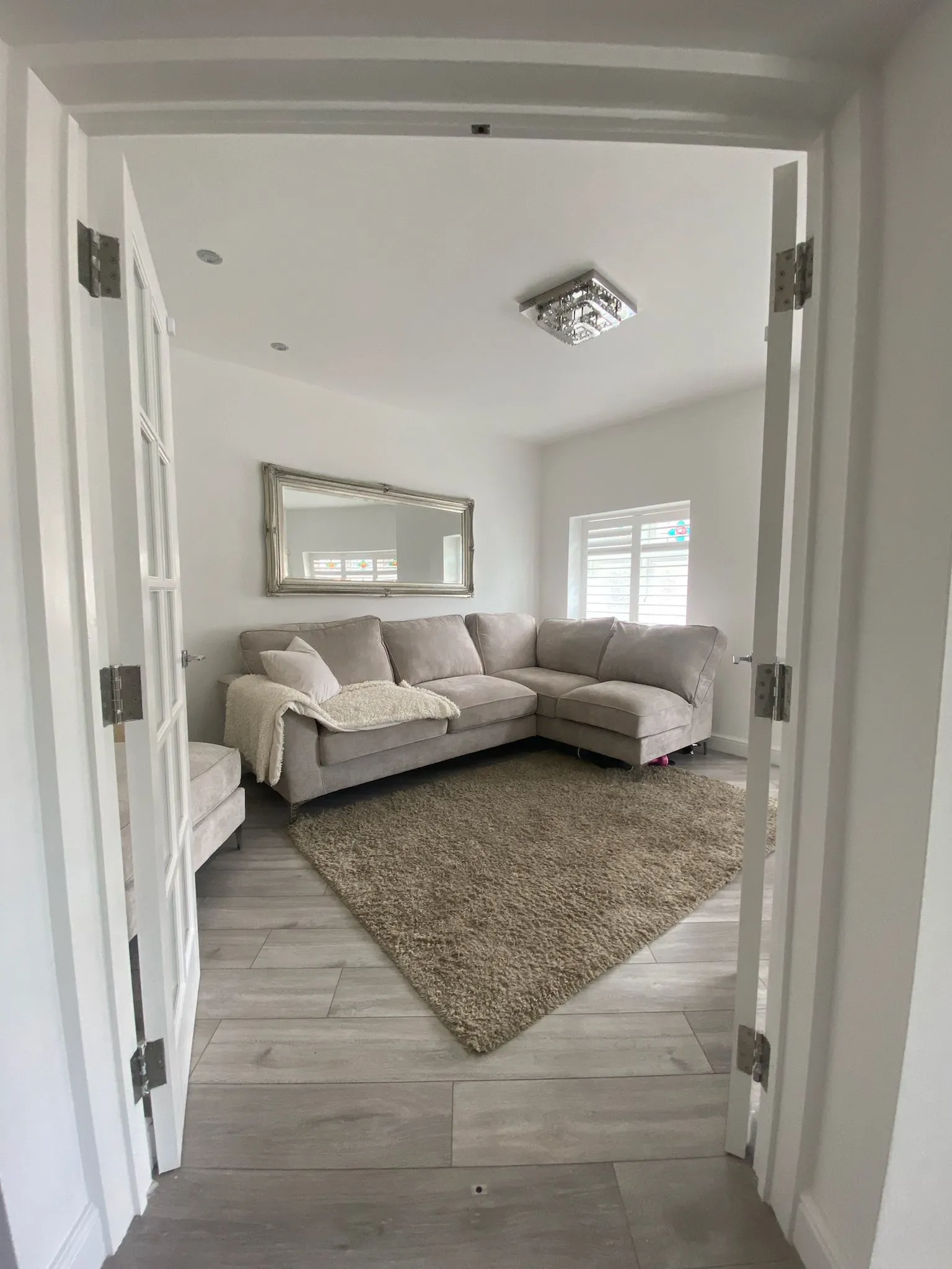 A living room with a couch and a rug on the floor.
