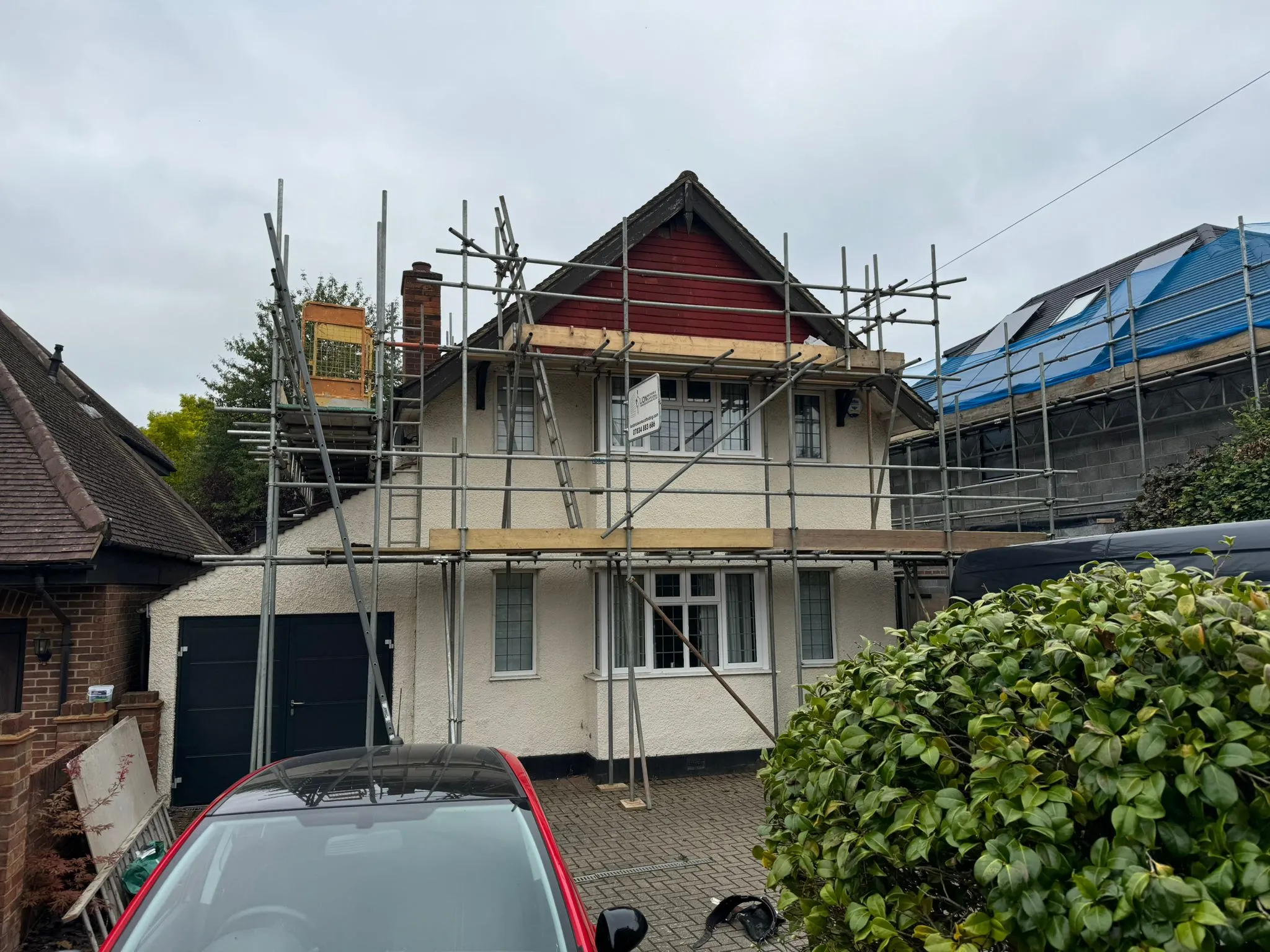 A house under construction with scaffolding on the roof.