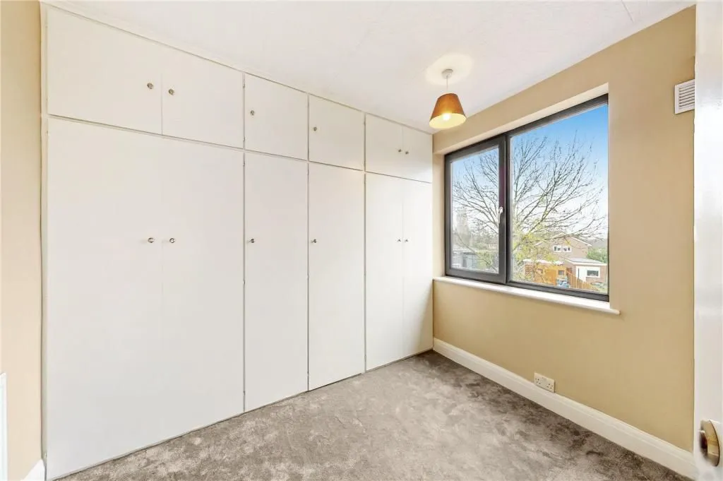 A room with a large window and white cabinets.
