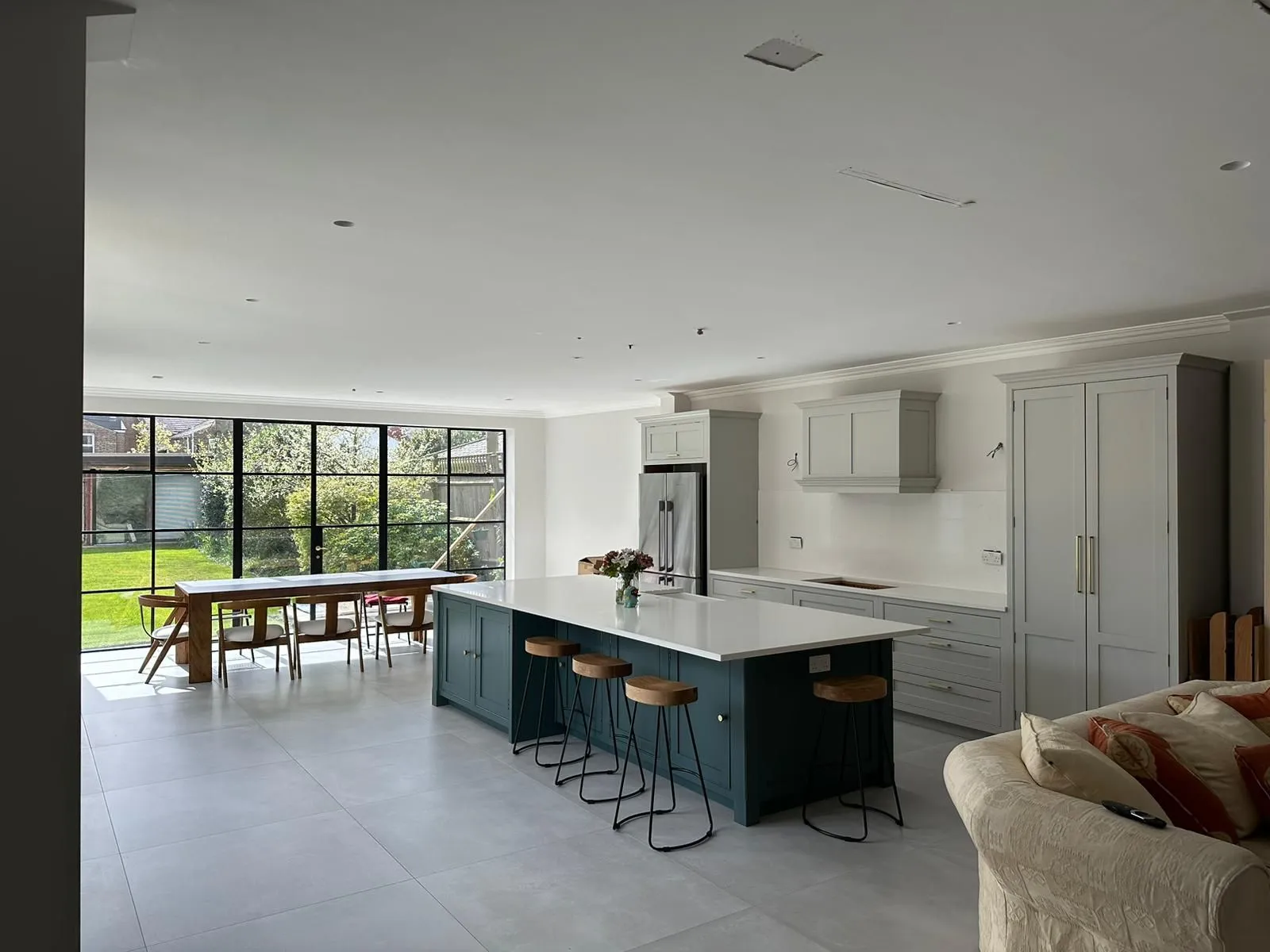 A large kitchen with a center island next to a living room.