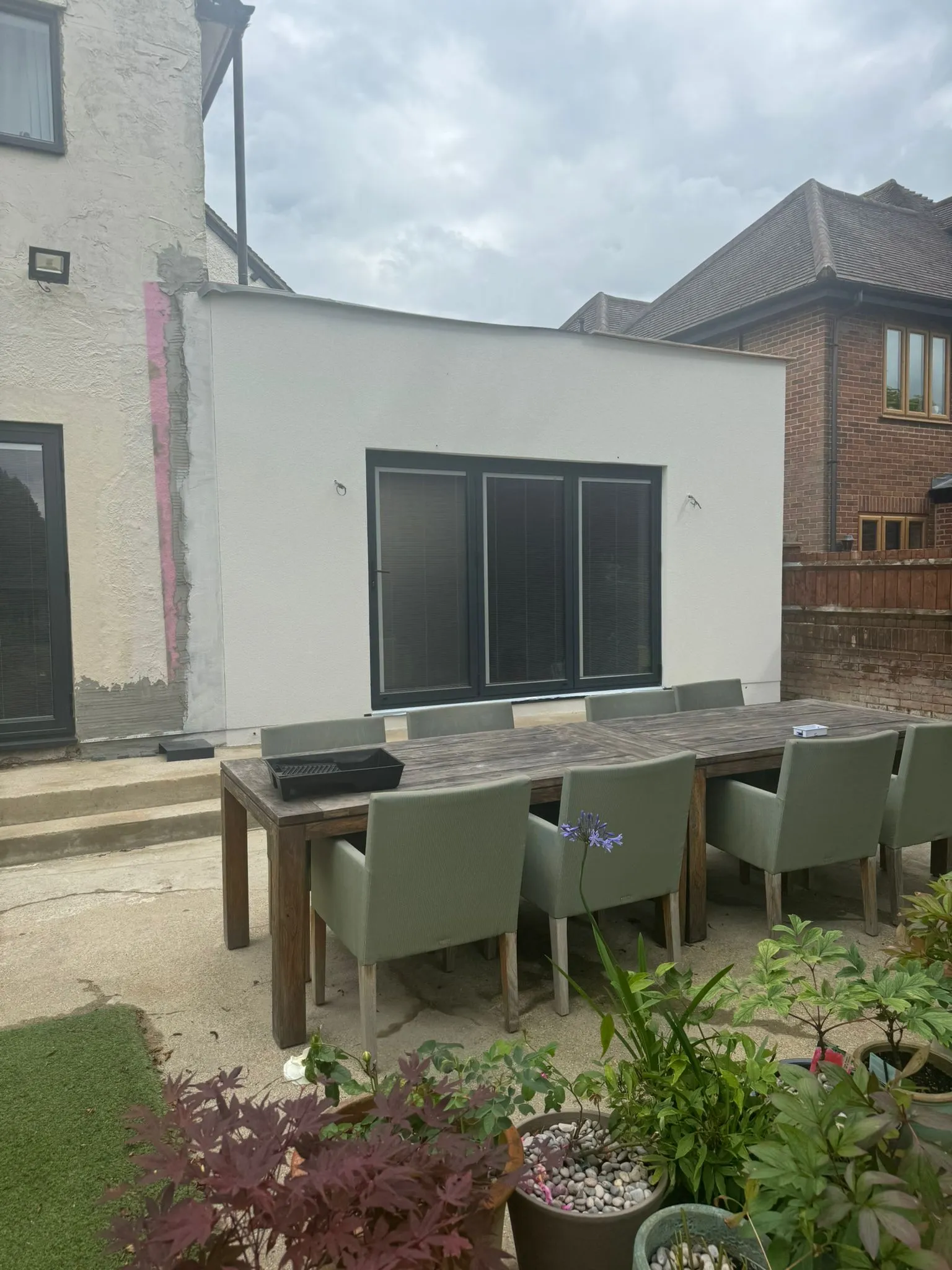 A table and chairs outside of a house.