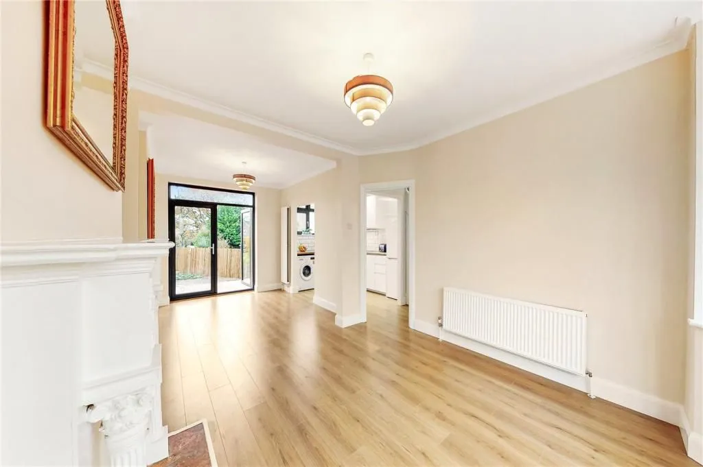 An empty living room with hard wood floors.