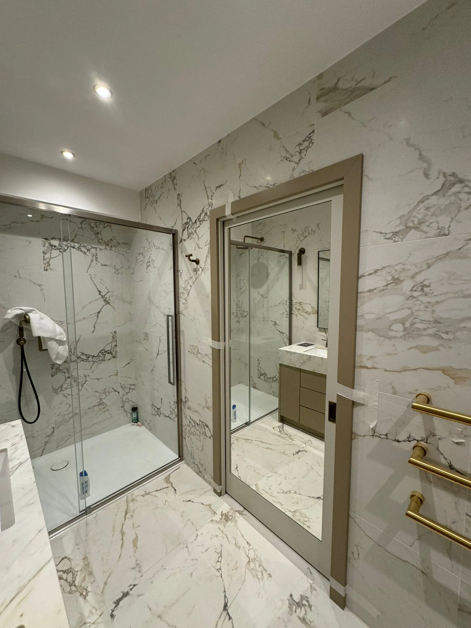 A bathroom with a walk in shower next to a sink.